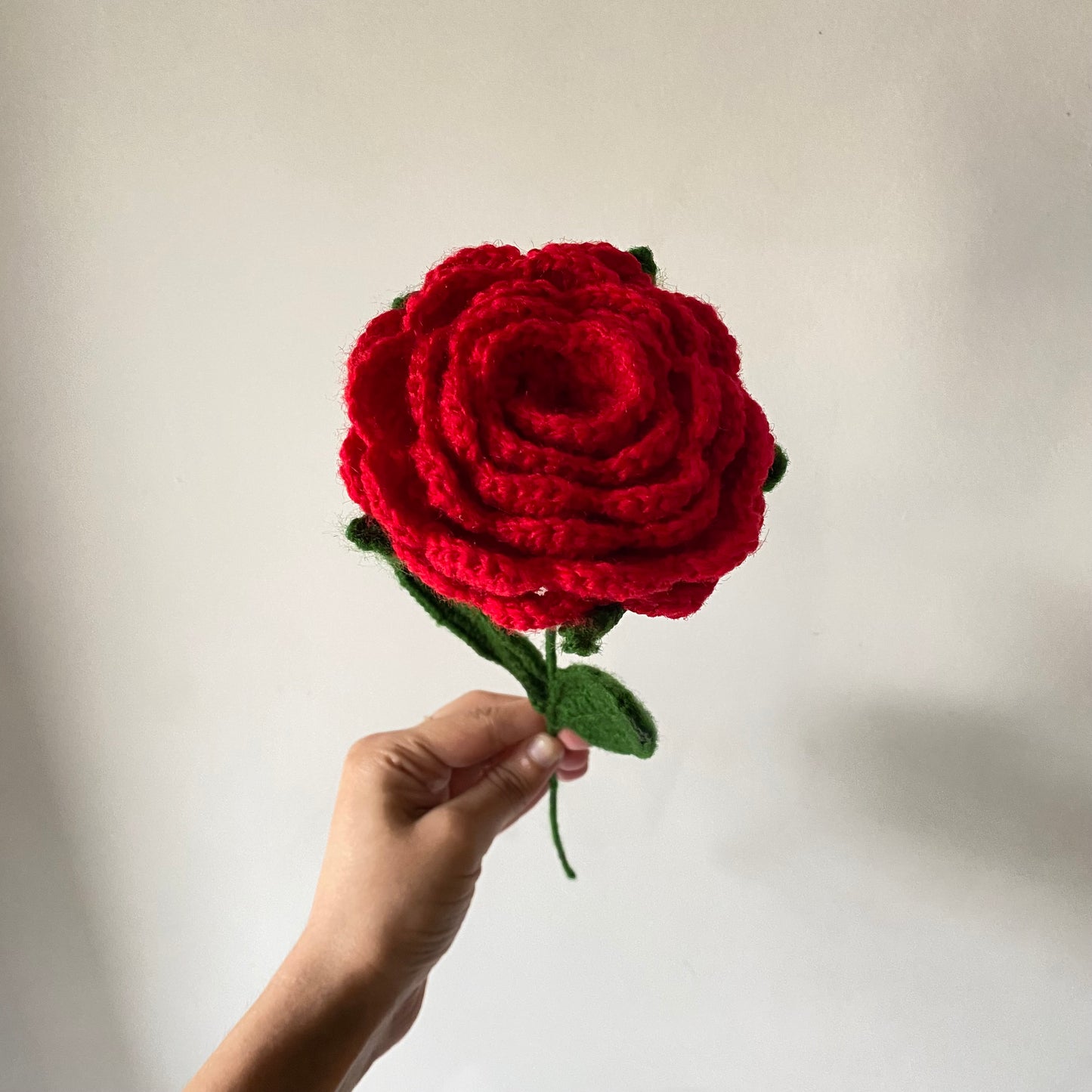 Close up picture of handmade red crochet rose